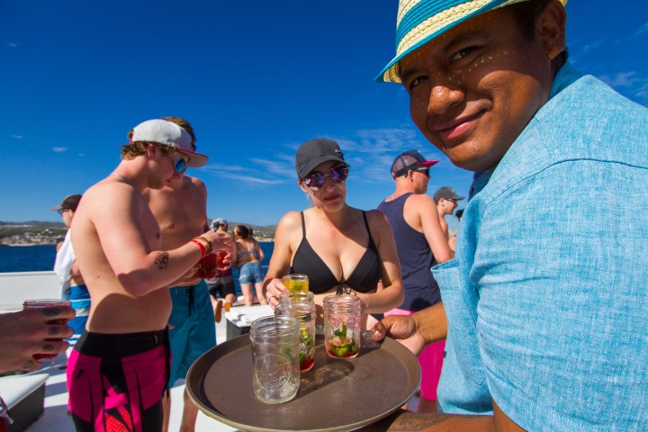a waiter serving drinks to people on a boat