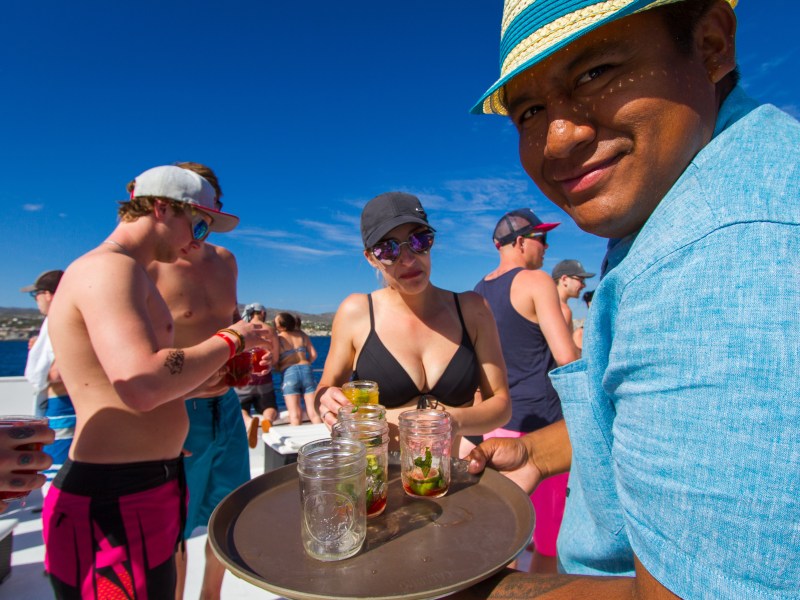 a waiter serving drinks to people on a boat