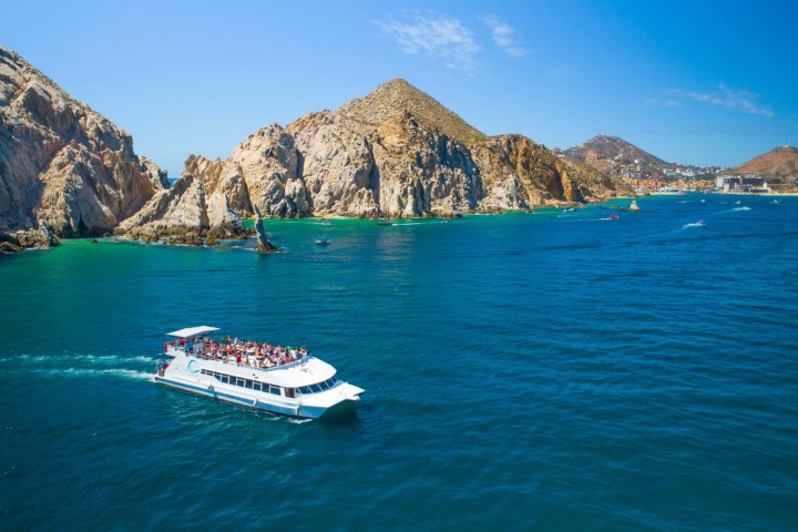 catamaran in a body of water with a mountain in the background