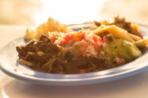 A dish of meat fajitas with guacamole