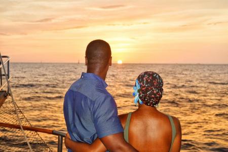 a couple standing on a boat next to a body of water