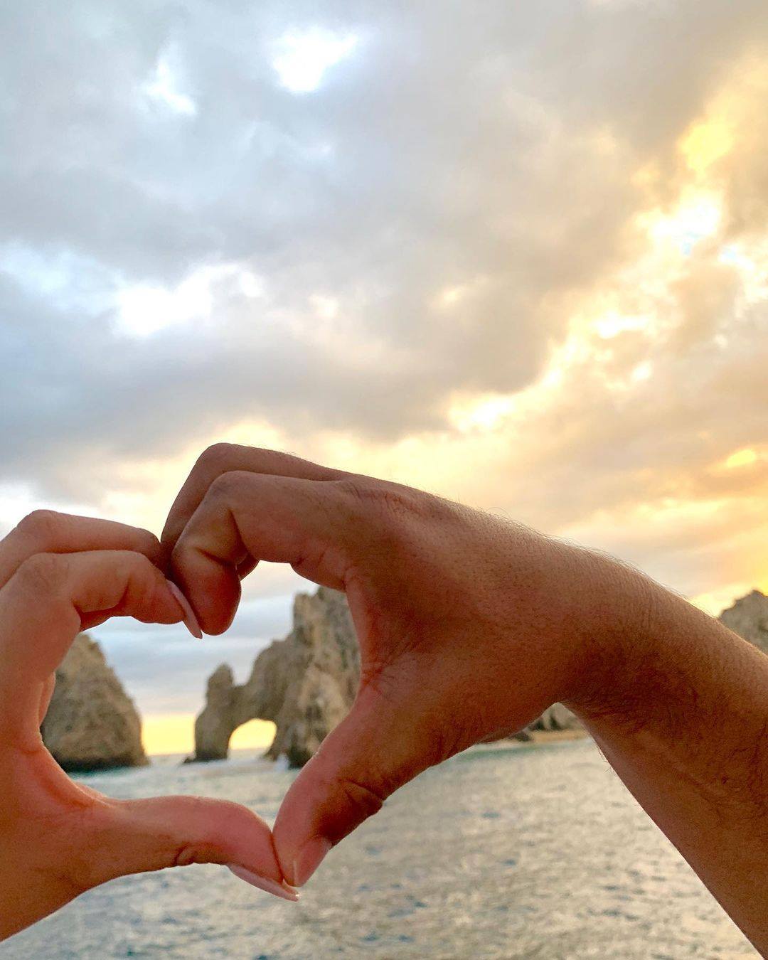WildCaboTours – Sightseeing 4 a heart made of hands with Cabo San Lucas' Arch in the background