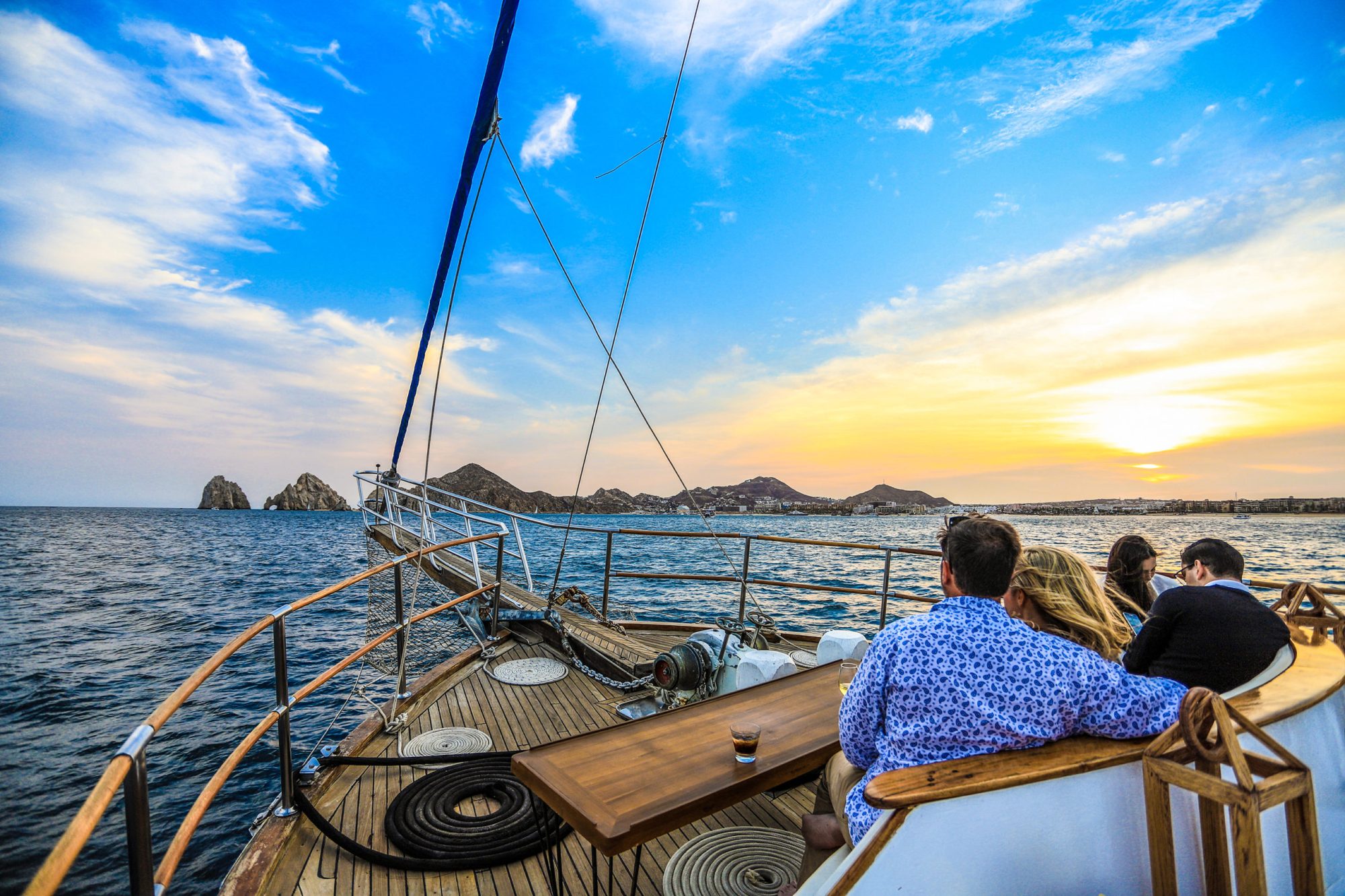 a couple sitting on a boat during sunset