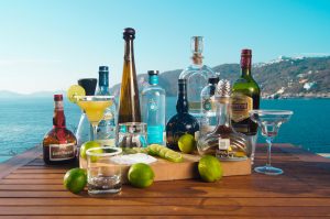 an array of bottles of liquor sitting on top of a wooden table