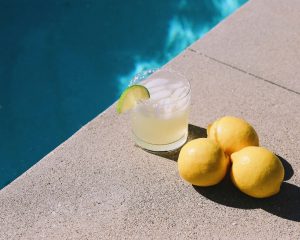 a glass with liquor by a pool